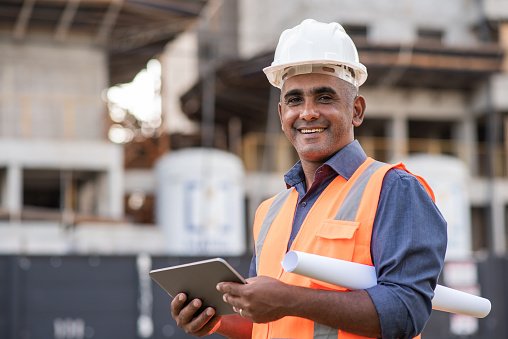 engineering holding a tablet and a plan